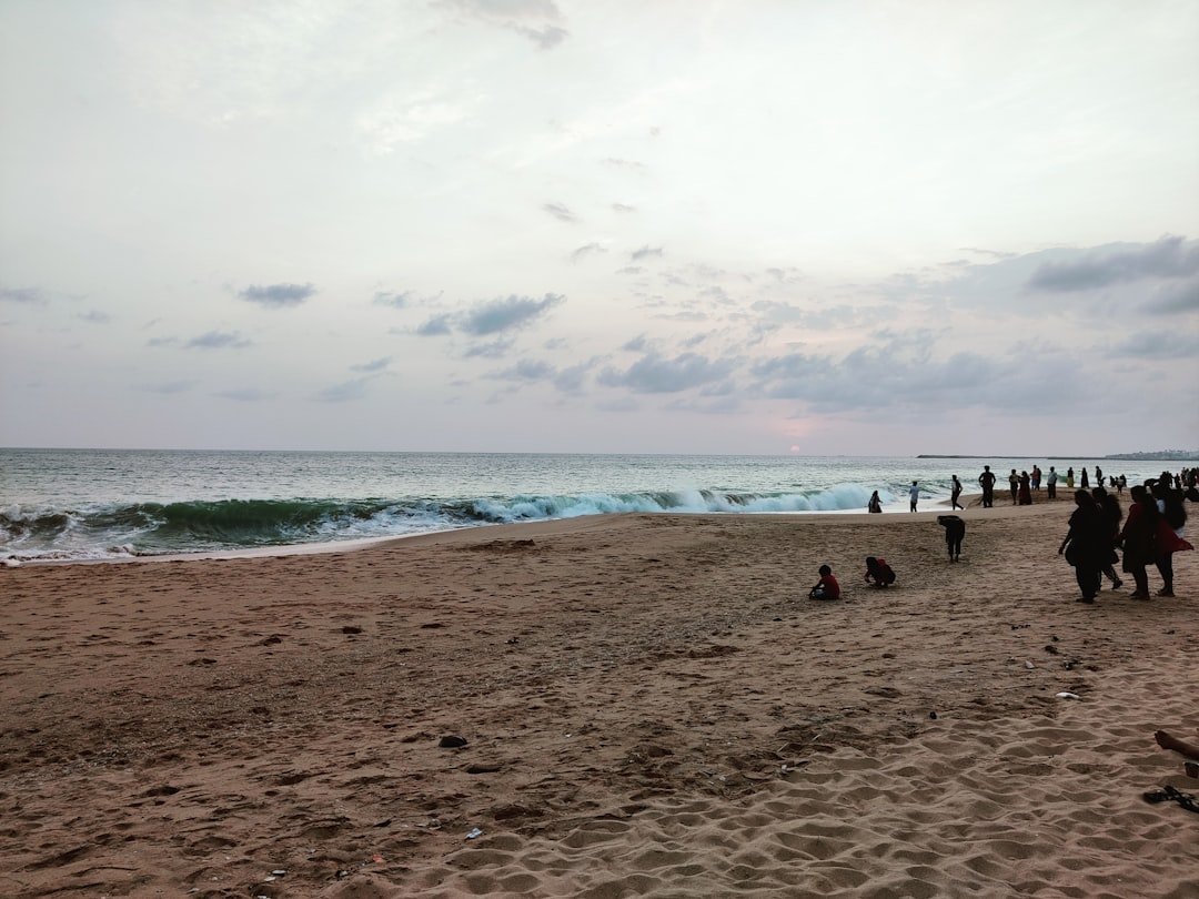 a group of people standing on top of a sandy beach
