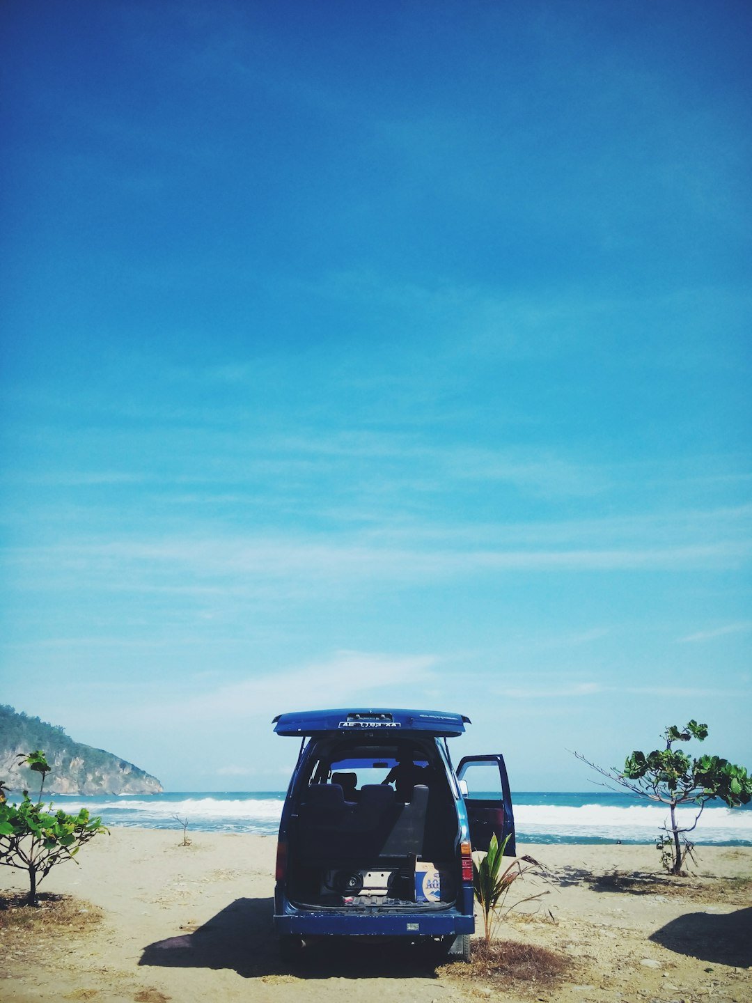 blue van on seashore during daytime