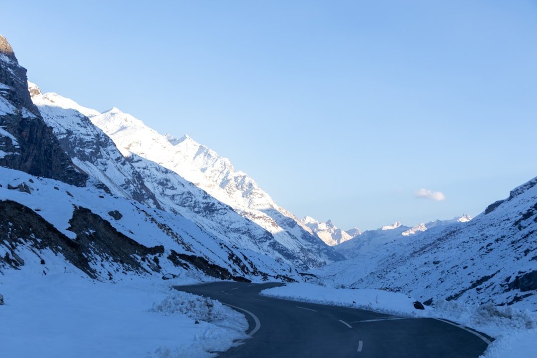 A snowy mountain road with a mountain in the background