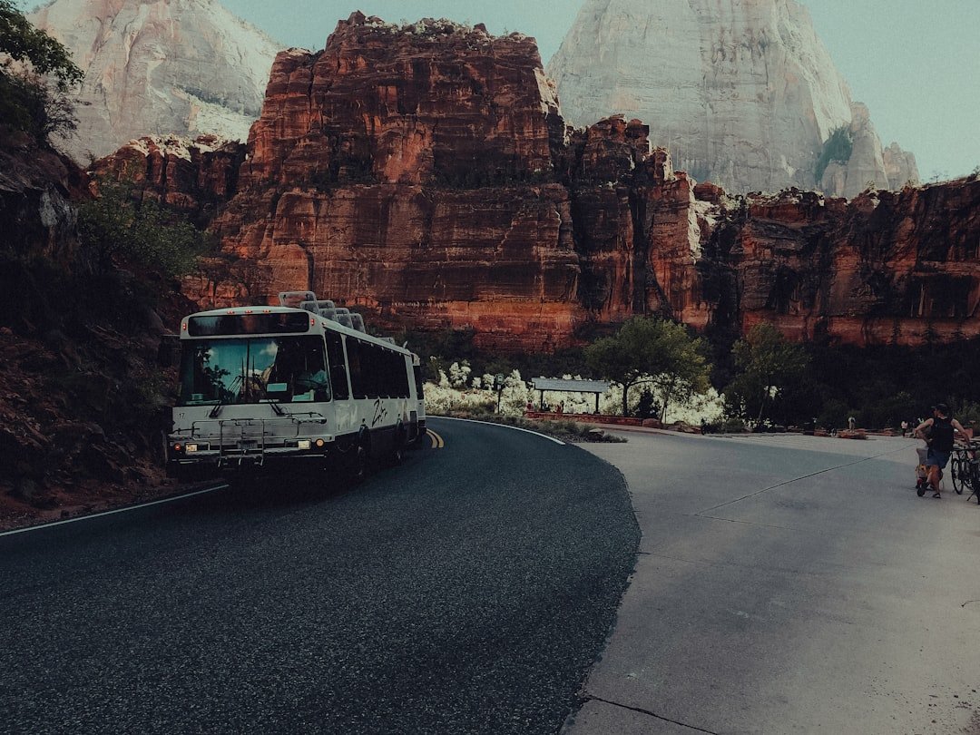 A bus driving down a road next to mountains