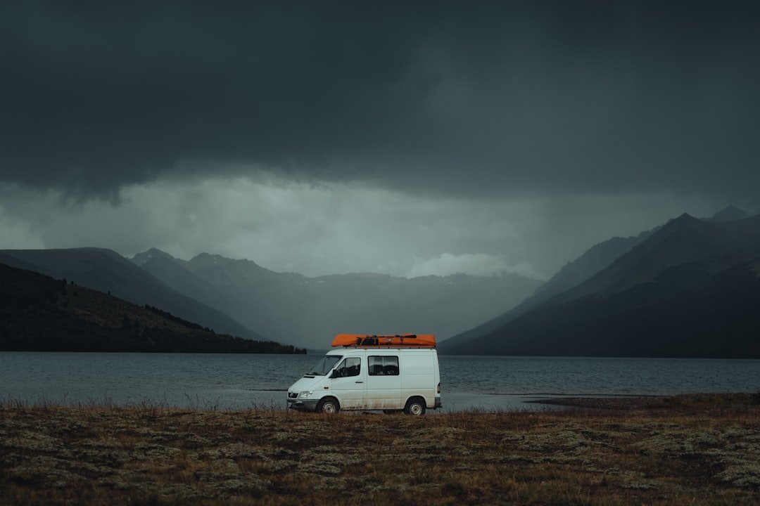 a van parked in a field with mountains in the background