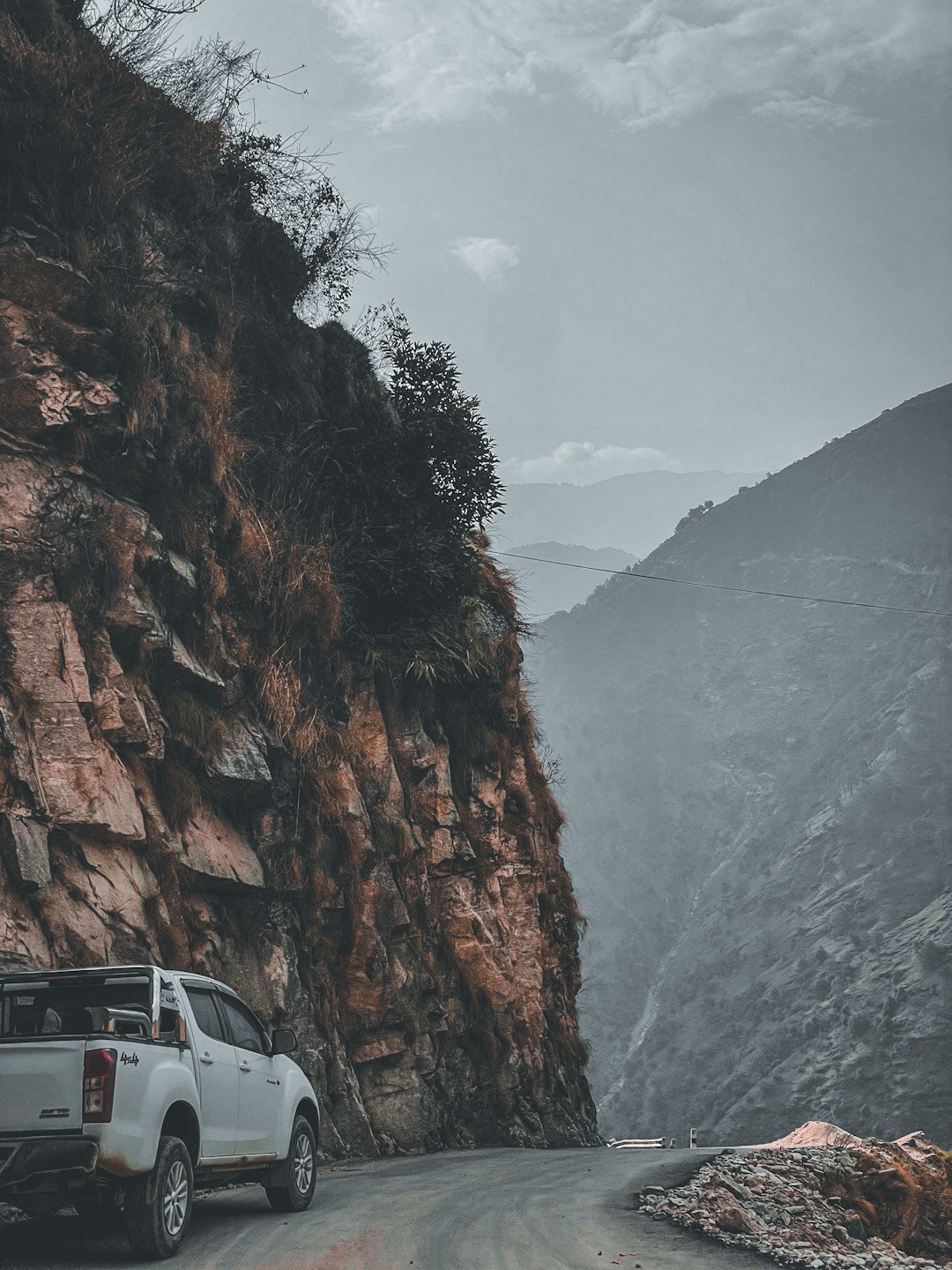 a white truck parked on the side of a mountain road