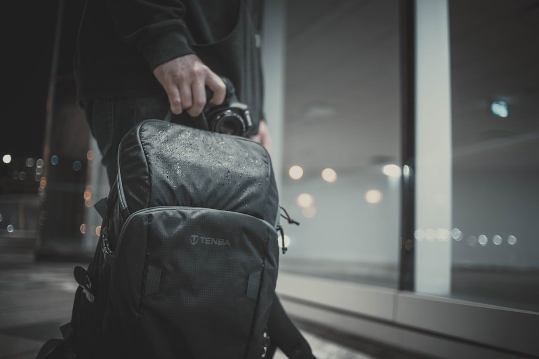 a man carrying a black backpack and a camera