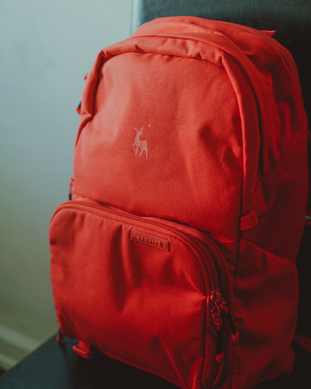 red and black backpack on white table