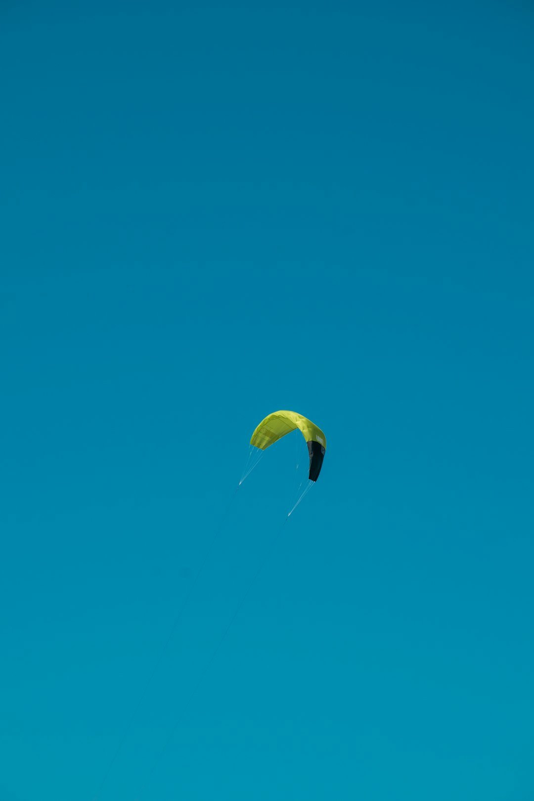 a kite is flying high in the blue sky