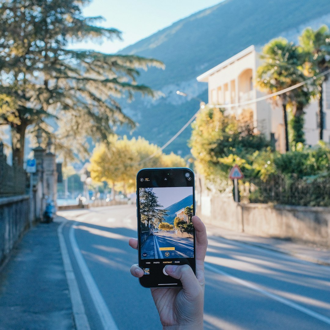 A person taking a picture of a street with a cell phone
