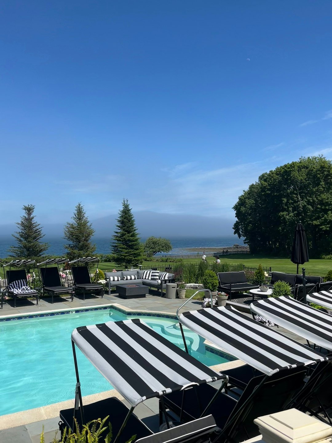 a large swimming pool surrounded by lawn chairs