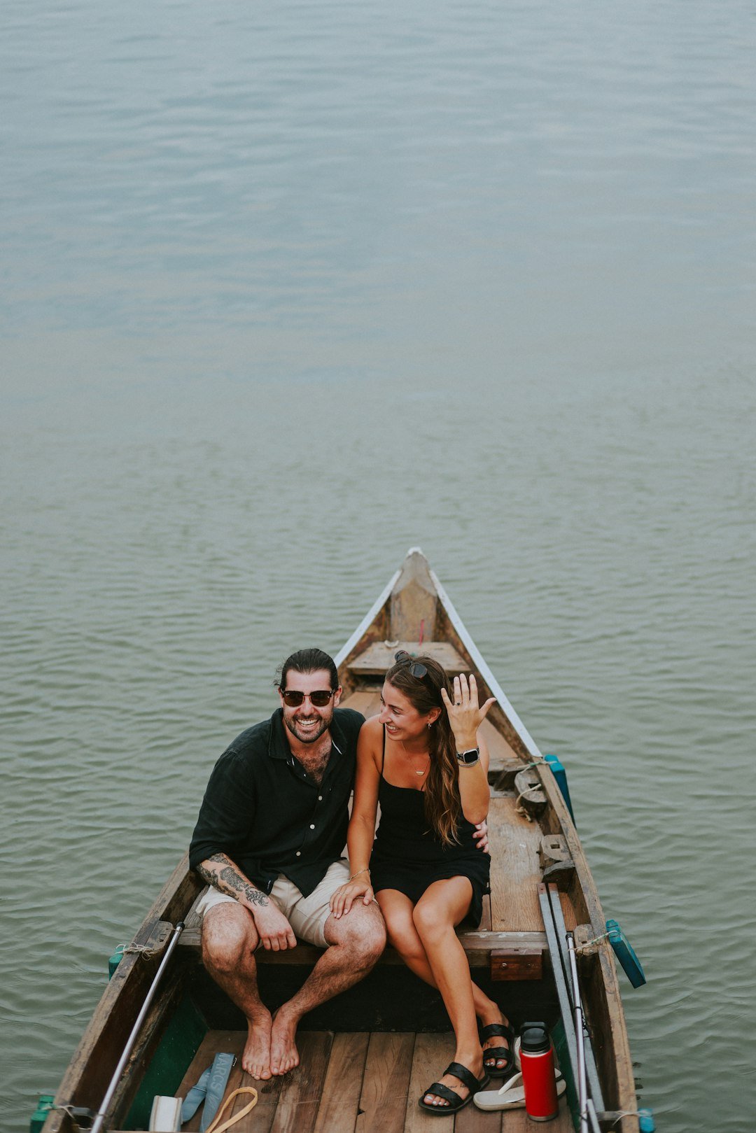 a man and woman sitting in a boat on the water