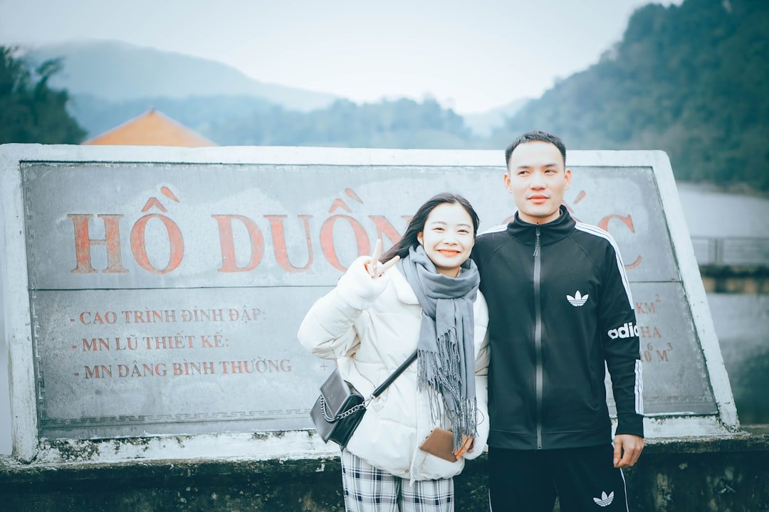 a man and a woman standing in front of a sign