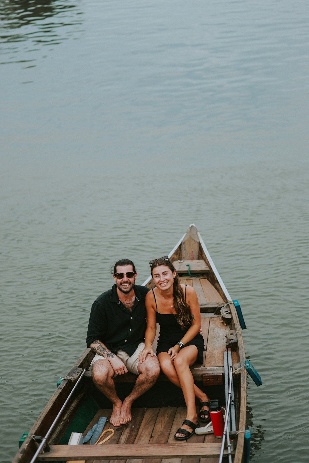 a man and a woman sitting in a boat on the water