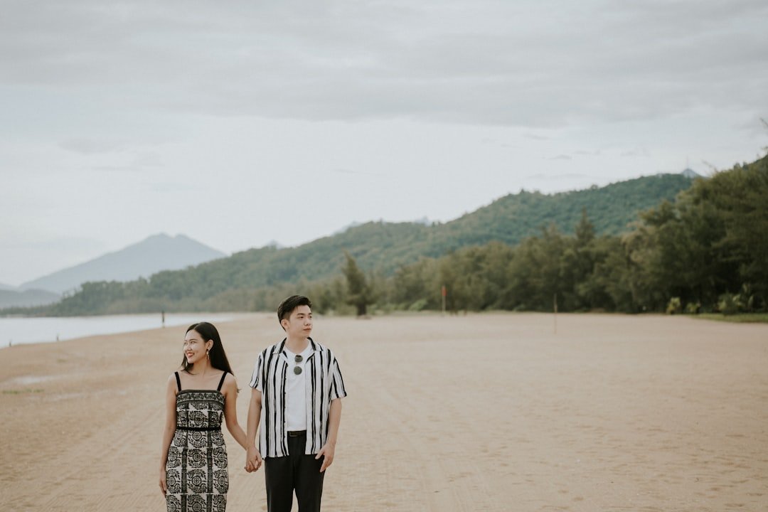 a man and woman standing on a beach