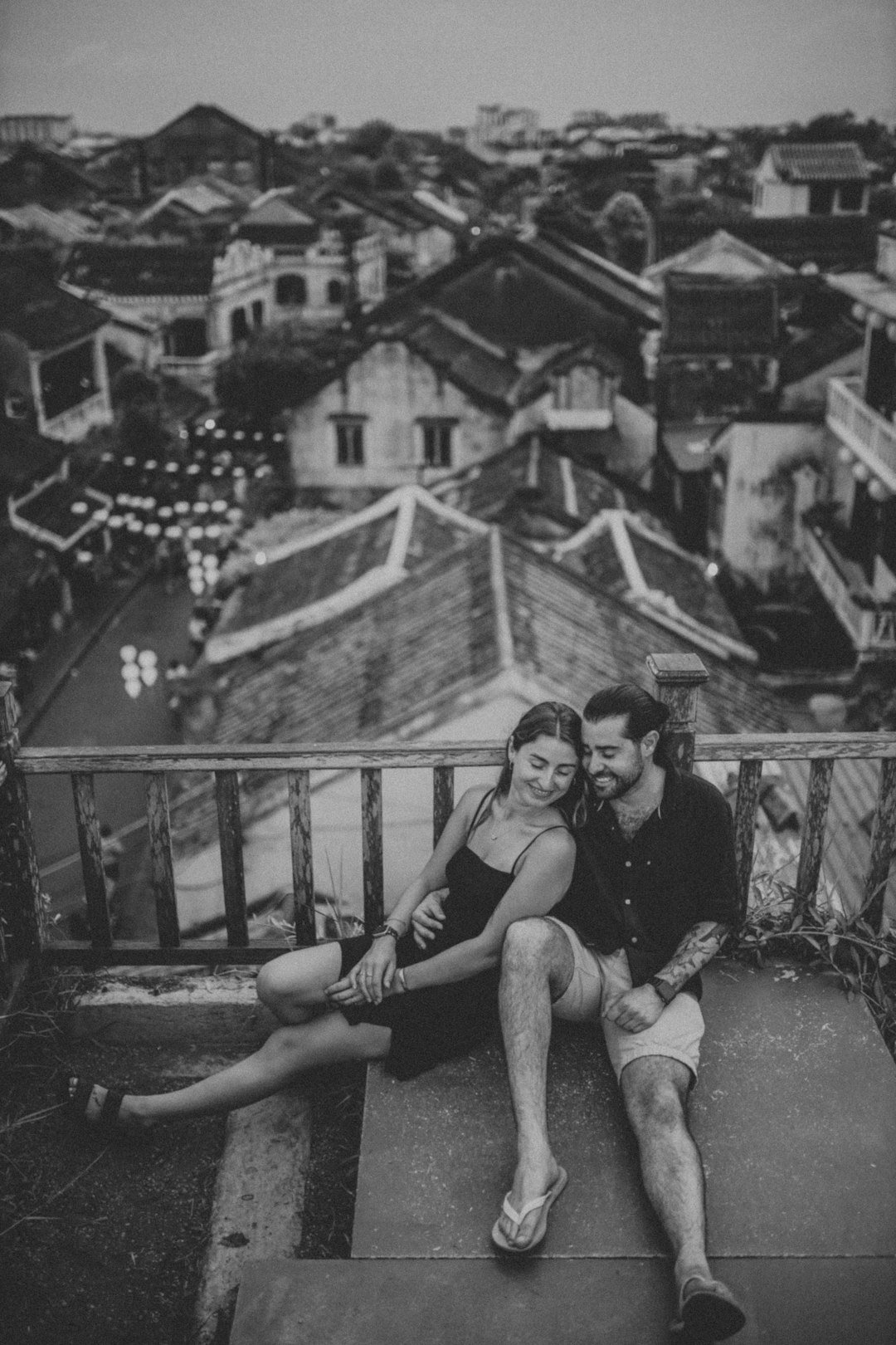 a man and woman sitting on top of a building
