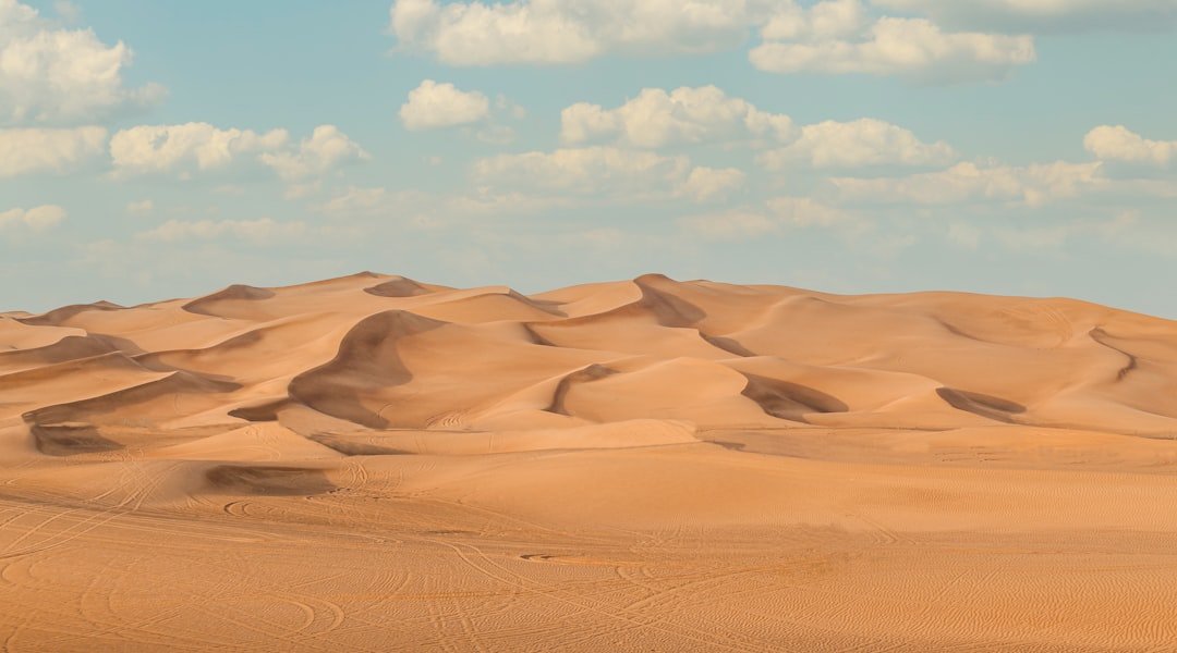 a large group of sand dunes under a blue sky