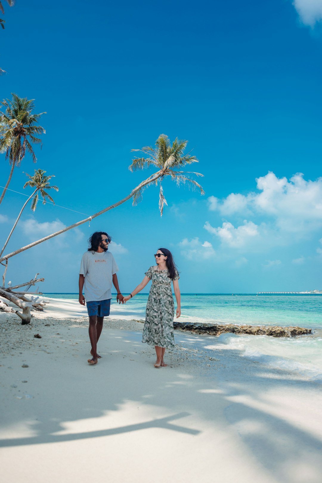 a man and woman walking on a beach
