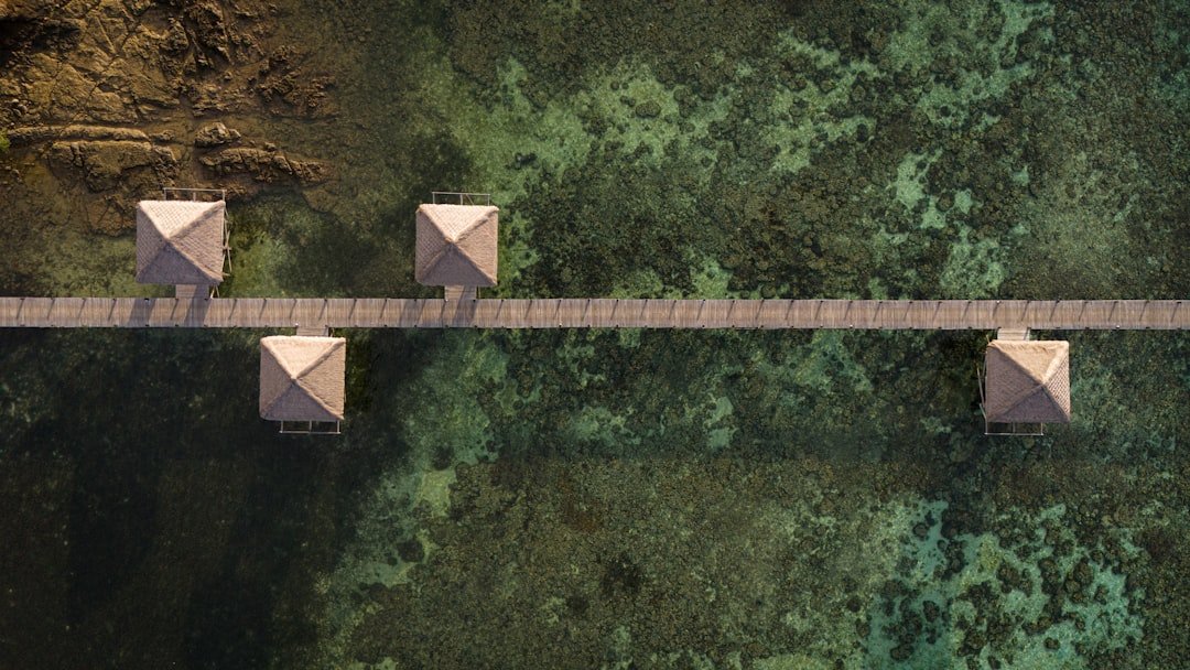 Overwater bungalows on a long wooden pier.
