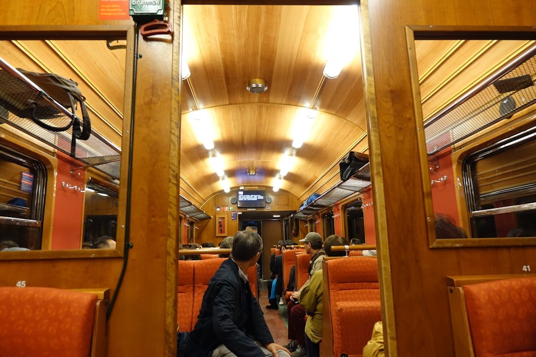 a man sitting on a train looking at his reflection in a mirror