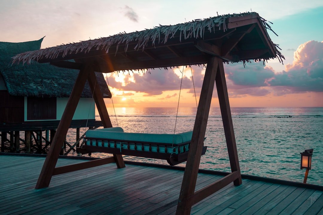 a swing bed sitting on top of a wooden pier