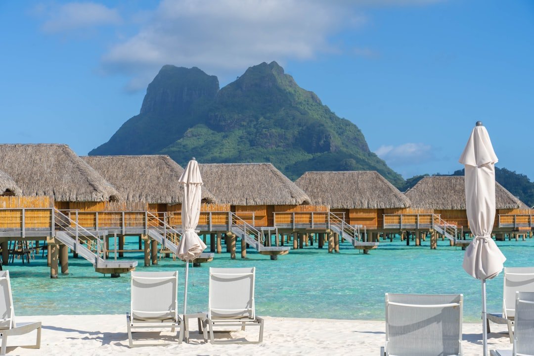 A beach with chairs and umbrellas and a mountain in the background