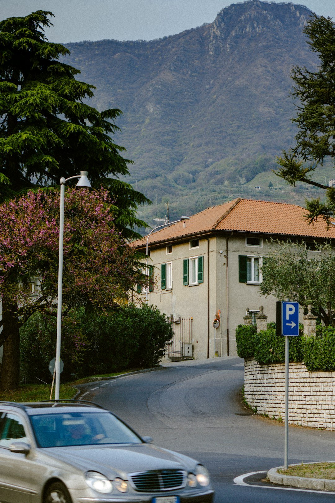 a car driving down a street in front of a house