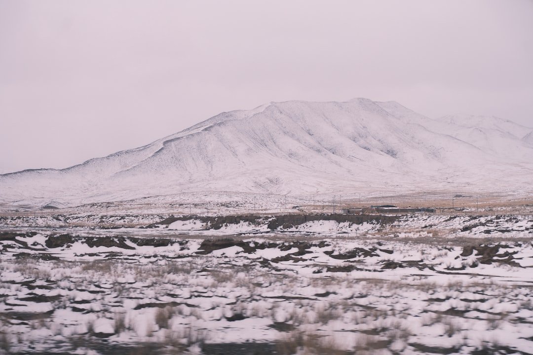 A snowy landscape with a mountain in the background