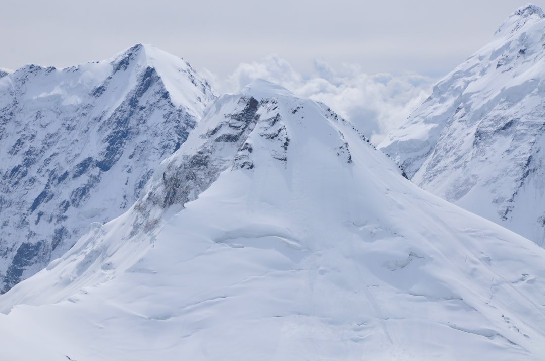 a snowy mountain with a valley below
