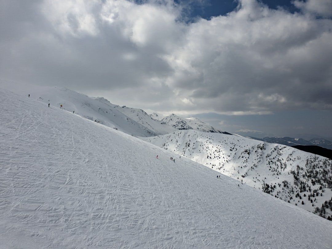 snow covered mountain under white clouds during daytime