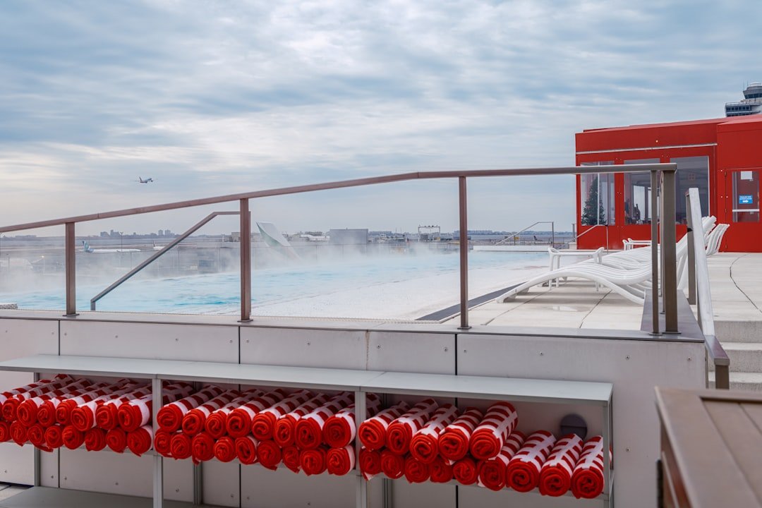 Rooftop pool with towels on a cloudy day.