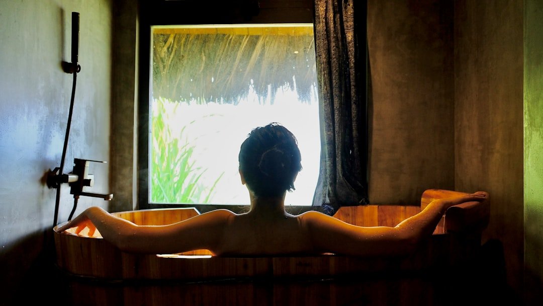 a woman sitting in a bathtub in front of a window