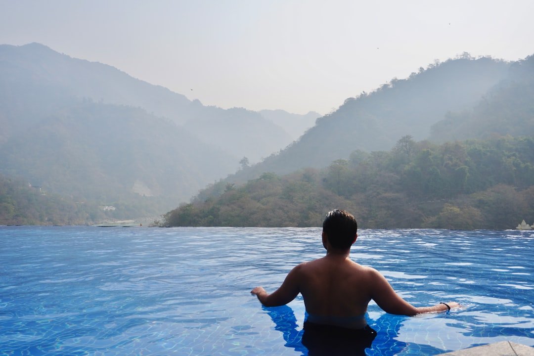 a person sitting in a pool with mountains in the background