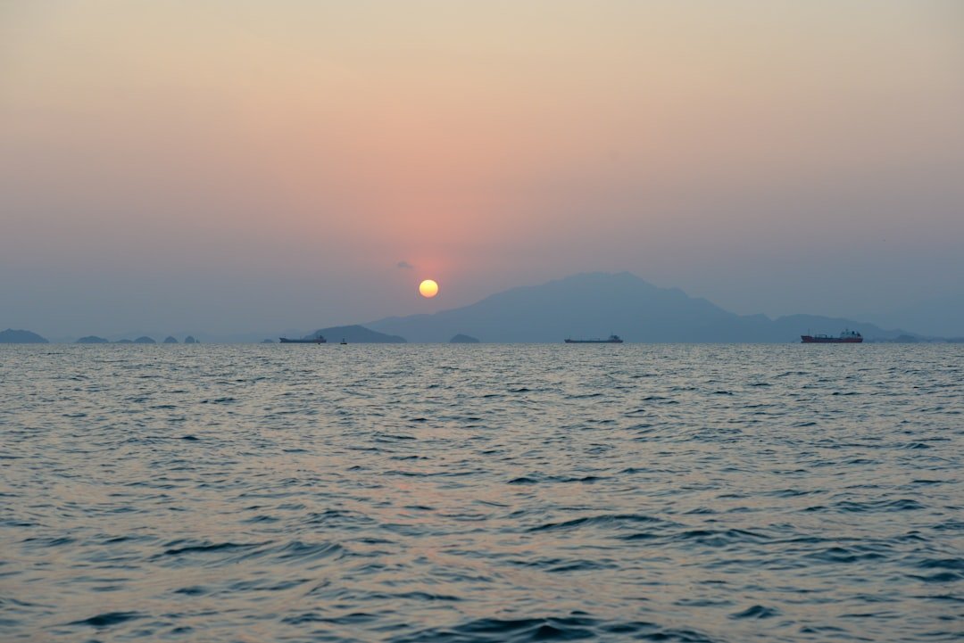 a body of water with boats in it and a mountain in the distance