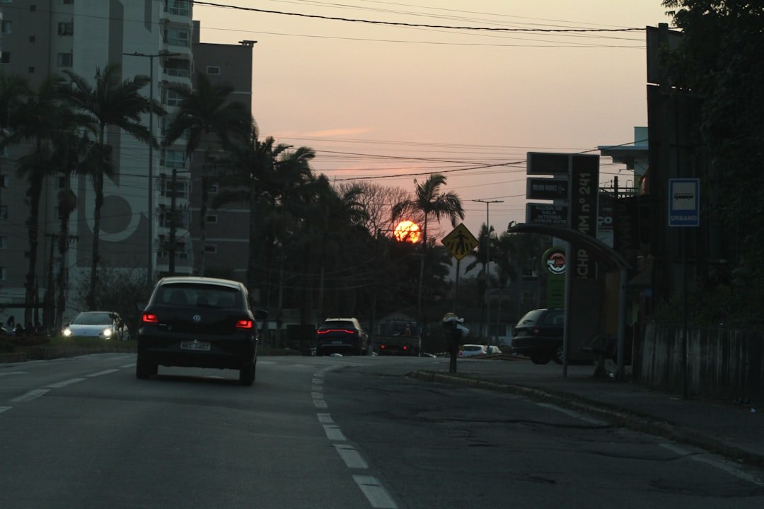 A car driving down a street next to tall buildings