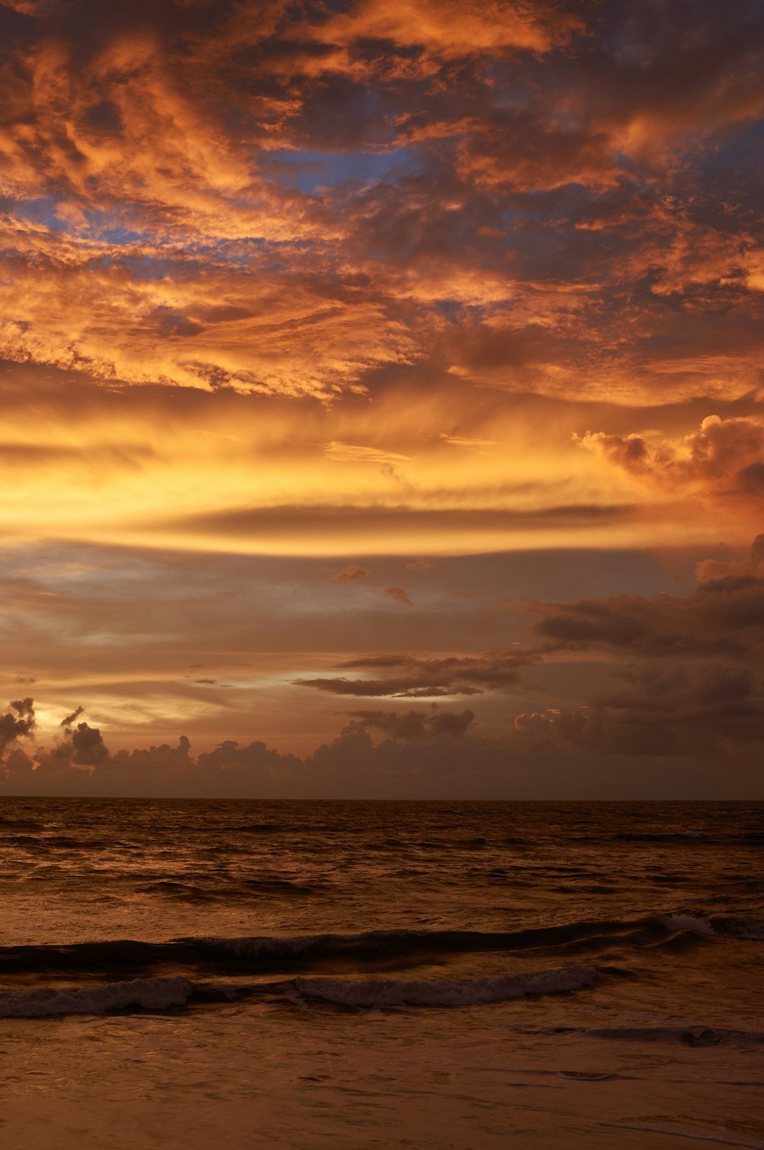A beautiful sunset over the ocean with clouds