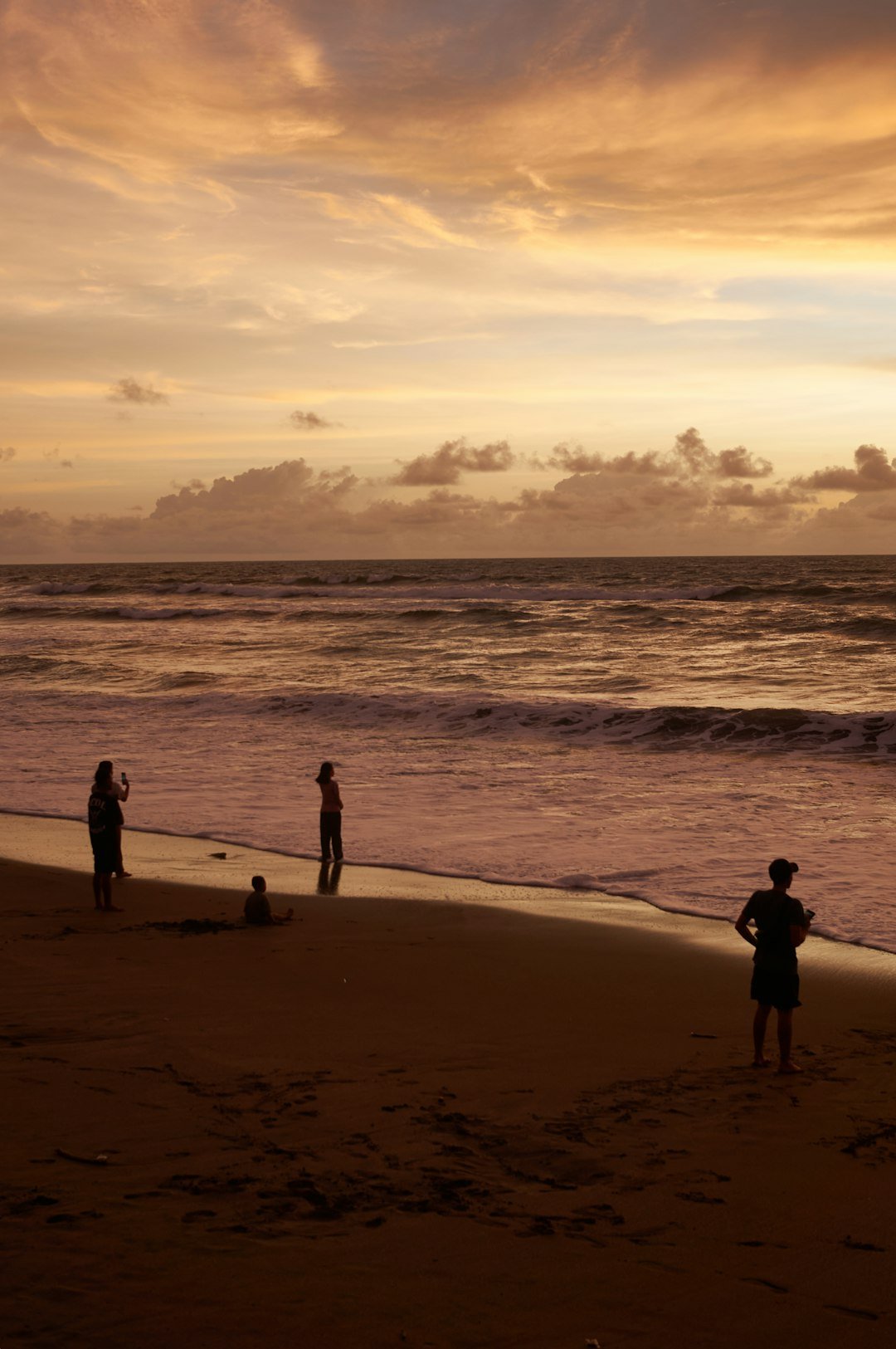 A group of people standing on top of a sandy beach