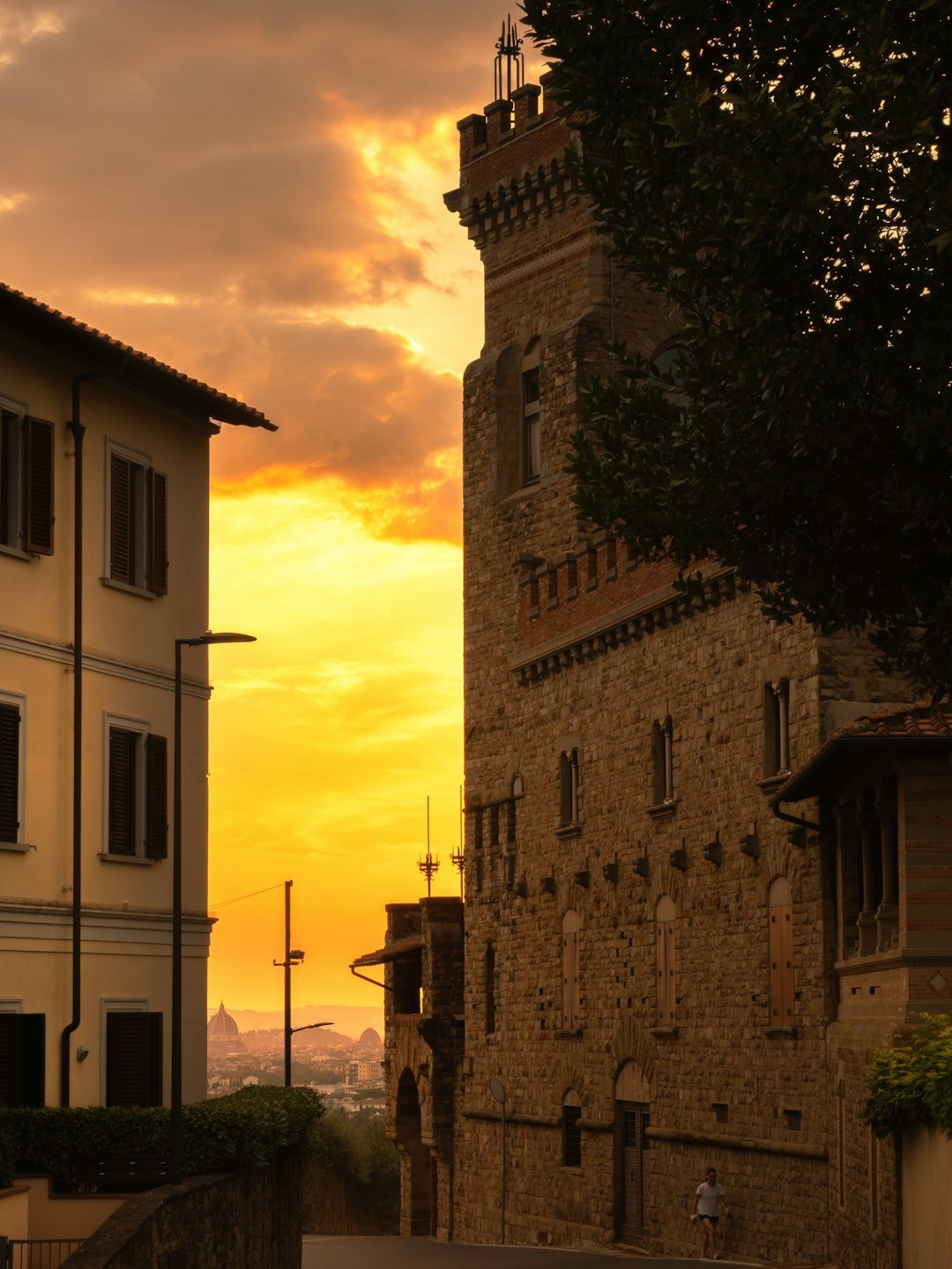 A clock tower towering over a city at sunset