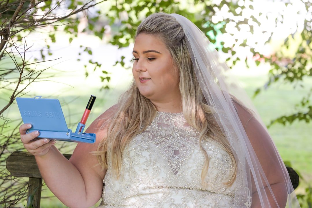 woman in white floral lace dress holding blue pen