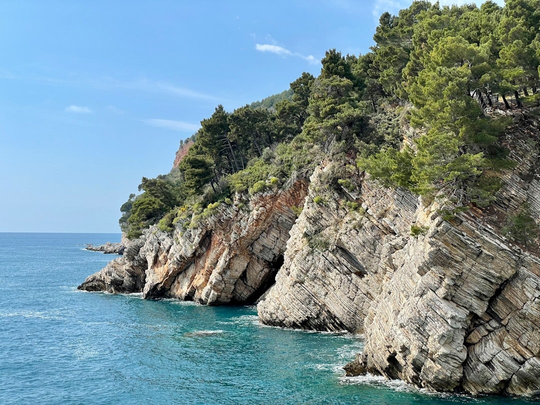 a large body of water next to a rocky cliff