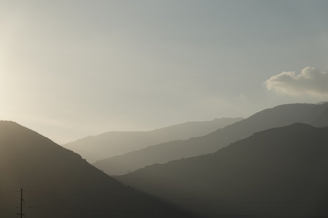 silhouette of mountains under white clouds during daytime